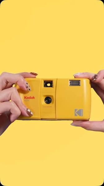 Yellow Kodak disposable film camera, held up ready to shoot